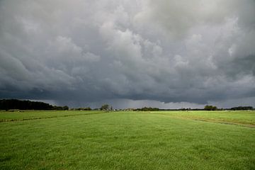 Onheilspellende donkere onweerslucht boven groen polderlandschap van Arjen Tjallema