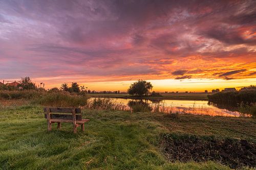 Profiter du lever de soleil coloré sur un banc en bois à la ferme Poel à Wormer sur Bram Lubbers
