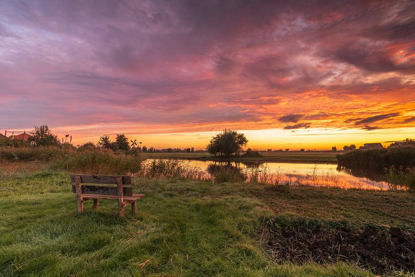 Enjoying the colourful sunrise on a wooden bench at the Poel farm in Wormer by Bram Lubbers