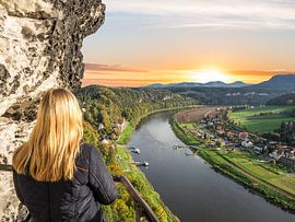 junge Frau blickt auf Rathen im Elbsandsteingebirge