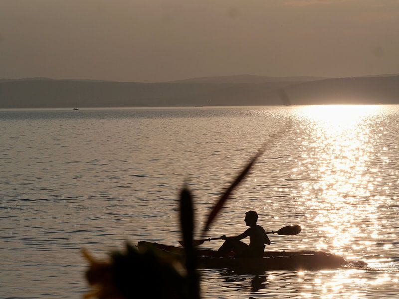 Man in canoe at sunset by Judith van Wijk