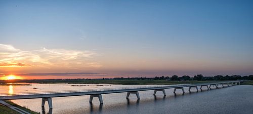 Panoramisch uitzicht over een brug over het Reevediep meer bij zonsondergang