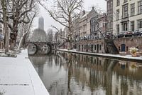Snow along the Oudegracht canal with the Dom tower in the background on a winter day in Utrecht, NL