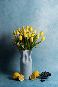 Stilleven met gele tulpen, citroenen en blauwe bessen