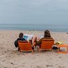 Samen op zaterdag de krant op het strand lezen van Robin Cox
