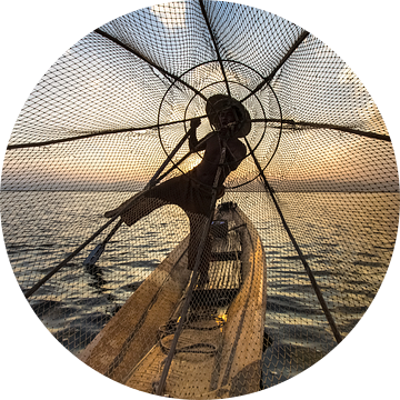 Visser die met traditionele boot op het Inle meer in Myanmar op ouderwetse wijze met een vis korf vi van Wout Kok