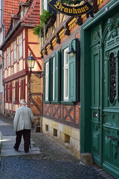 Alter Mann mit Spazierstock in einer idyllischen deutschen Fachwerkhausstraße von Studio LE-gals