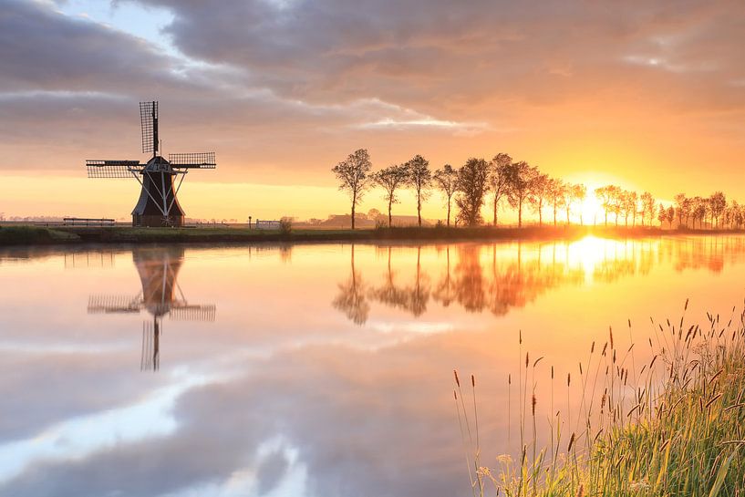 Nederlandse windmolen tijdens prachtige zonsopgang, Nederland van Olha Rohulya