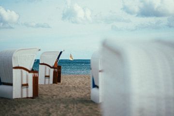 Voilier sur la mer Baltique photographié à travers des chaises de plage
