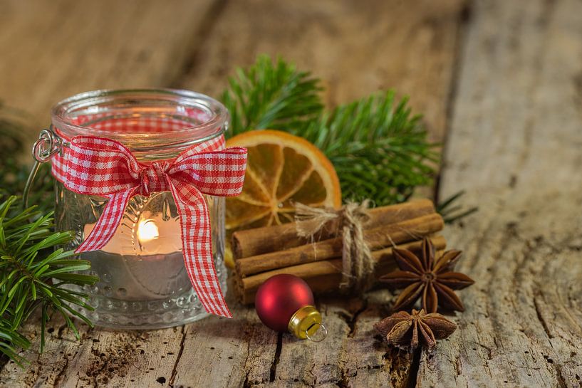 Advent and Christmas candle lantern with natural decoration on wooden table by Alex Winter