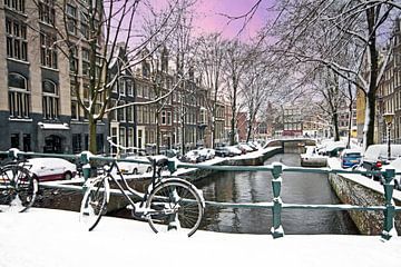 Besneeuwd Amsterdam in Nederland in de winter bij zonsondergang van Eye on You