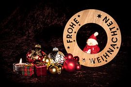 "Merry Christmas" with figure, Christmas tree balls and candle in front of brown velvet ba by Hans-Jürgen Janda