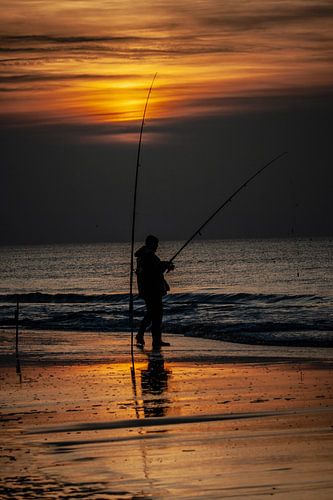 silhouet van een visser op het Noordwijkerstrand