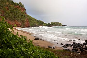 Strand omgeven door rode rotsen