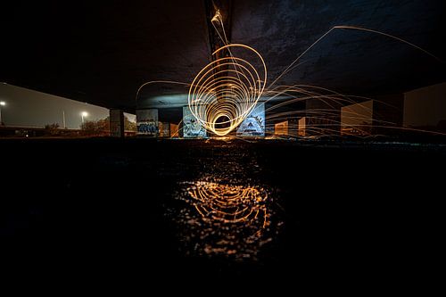 Lightpainting in spinning tunnel shape under viaduct