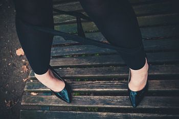 Frauenbeine mit heruntergelassener Unterwäsche und hohen Absätzen