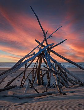 Branch building at sunset on the beach. by Albert Brunsting