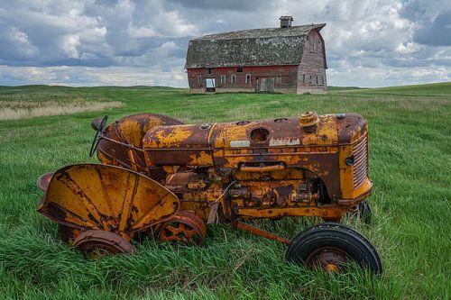 Dilapidated farmhouse and tractor in Canada
