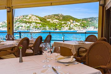 Tafel dekken bij restaurant aan zee met prachtig uitzicht op zee van Alex Winter
