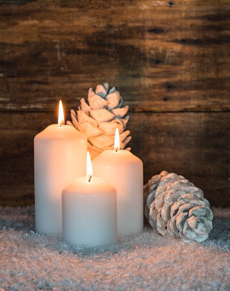 Advent en Kerstmis kaars vlammen met dennenappels decoratie op sneeuw van Alex Winter