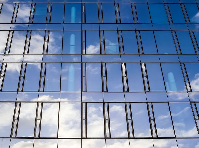 Spiegelde Häuserfassade moderner Bürogebäude bei blauem Himmel von MPfoto71