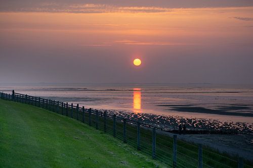 Zonsondergang aan de dijk