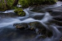 Stromend water met engelenhaar langs de rotsen
