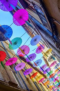 Bunte Regenschirme hängen als bunte Dekoration über der Straße