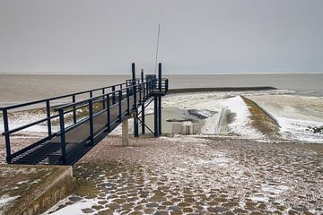 Winterse Waddenzee bij Roptazijl. IJsschotsen drijven op het water van