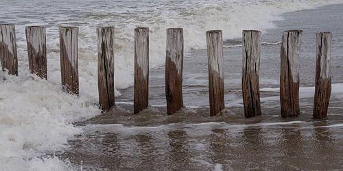Golven met golfbrekers op het strand van Cadzand, Zeeland