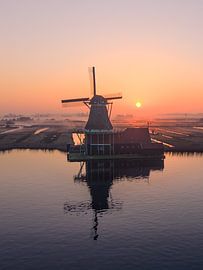 A solitary windmill in the polder at sunrise by Thijs Friederich