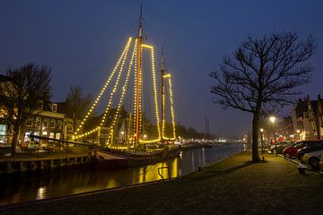 Geschmücktes traditionelles Segelschiff im nächtlichen Hafen von Harlingen in Friesland, Niederlande von Eye on You