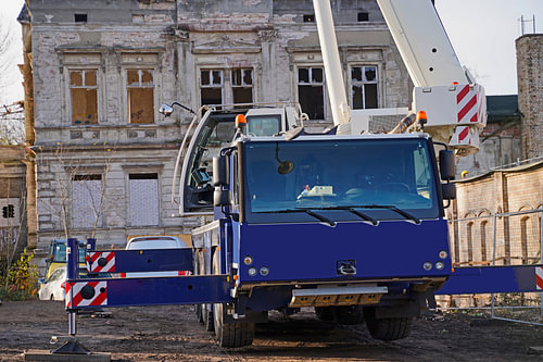 Bouwvoertuigen en -materiaal brengen een betonnen ring aan op een oude graanelevator.