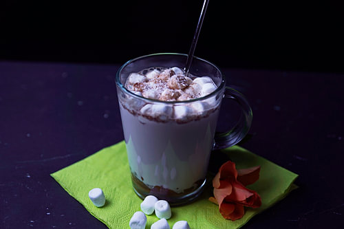 Warme cacao met chocoladelikeur kokoswhisky en schuimsuikerbolletjes in een glas