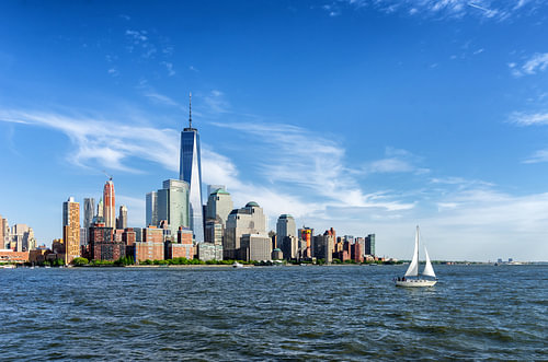 Vue de Manhattan à New York sur l'eau avec un voilier au premier plan.