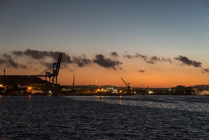 Sunset over the harbor of Valletta, Malta with sea cranes and an by Werner Lerooy