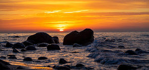 Panorama Sonnenuntergang am Strand mit großen Felsen im Wasser an der Ostsee auf Rüge