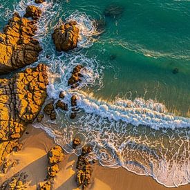 Eine Drohnenperspektive von oben. Das zentrale Motiv bleibt die Küstenlinie, wo Meer und Sand aufein von Artkreator