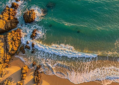 Eine Drohnenperspektive von oben. Das zentrale Motiv bleibt die Küstenlinie, wo Meer und Sand aufein von Artkreator
