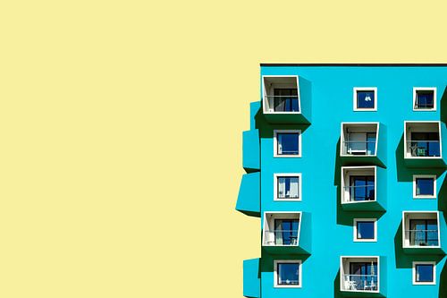 Groen blauw gebouw tegen gele lucht