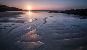 Zonsondergang bij eb op het strand