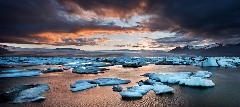 A glowing sunset over the glacier lagoon in Iceland van Olga Ilina
