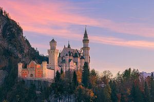 Schloss Neuschwanstein bei Sonnenuntergang im Herbst beleuchtet