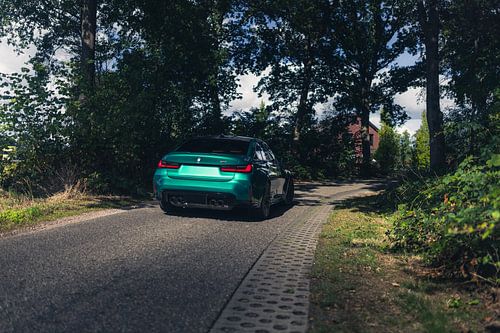Groene BMW M3 G80 in een rustgevende, bosrijke omgeving