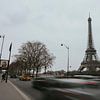 Eiffelturm entlang einer Straße mit fließendem Verkehr von Manon Visser