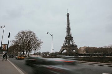 Eiffel tower along road with moving traffic