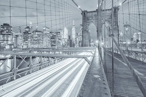 Een zwart-wit opname van de Brooklyn Bridge in Manhattan in New York. Op de achtergrond word de skyl