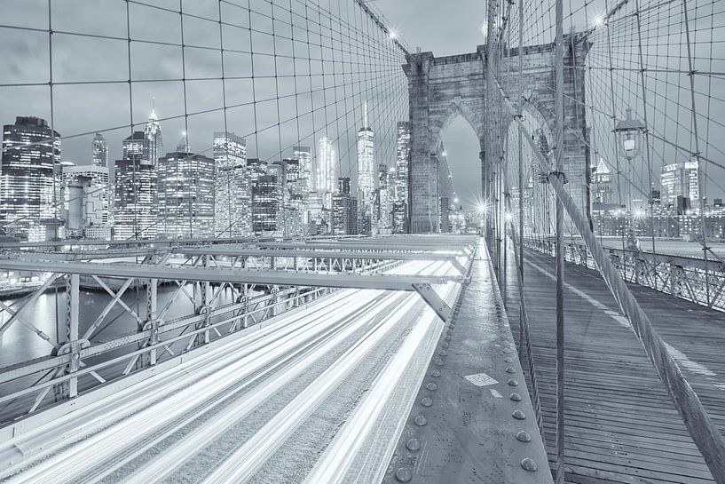 Een zwart-wit opname van de Brooklyn Bridge in Manhattan in New York. Op de achtergrond word de skyl van Bas Meelker