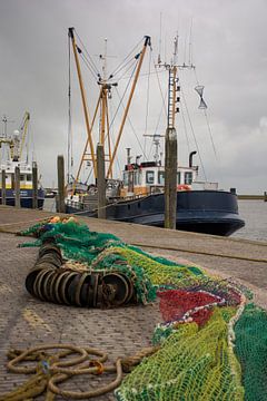 Visserschepen en netten aan de kade van de haven van scheepskijkerhavenfotografie