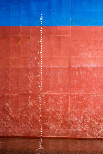 IJkmerk en een bijna leeg zeeschip in de haven.